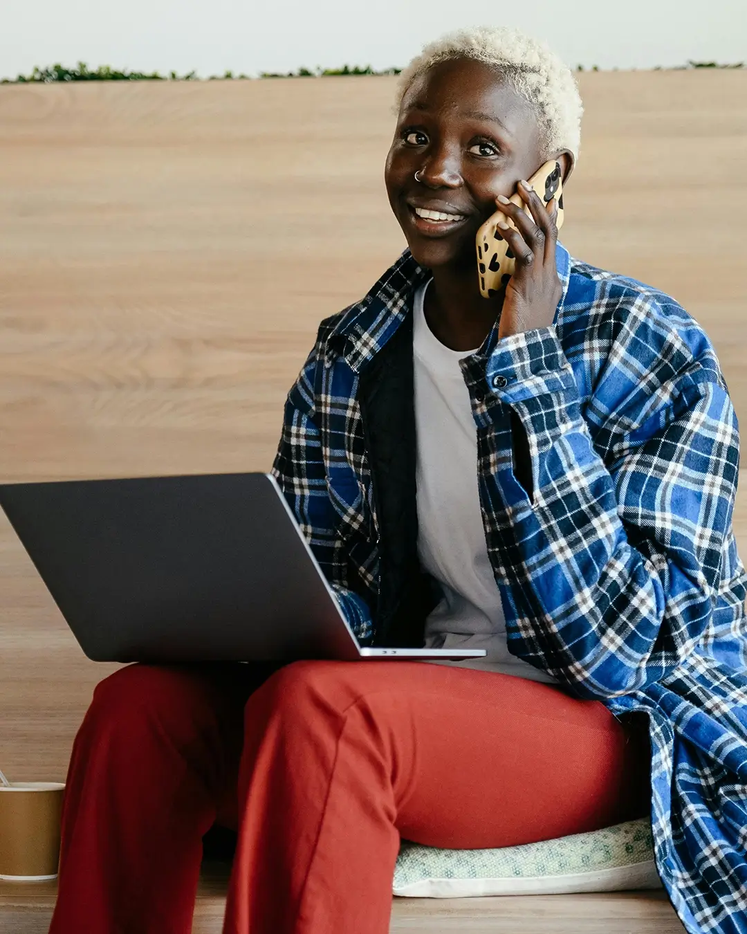 Picture of woman on the phone with her laptop in her lap.